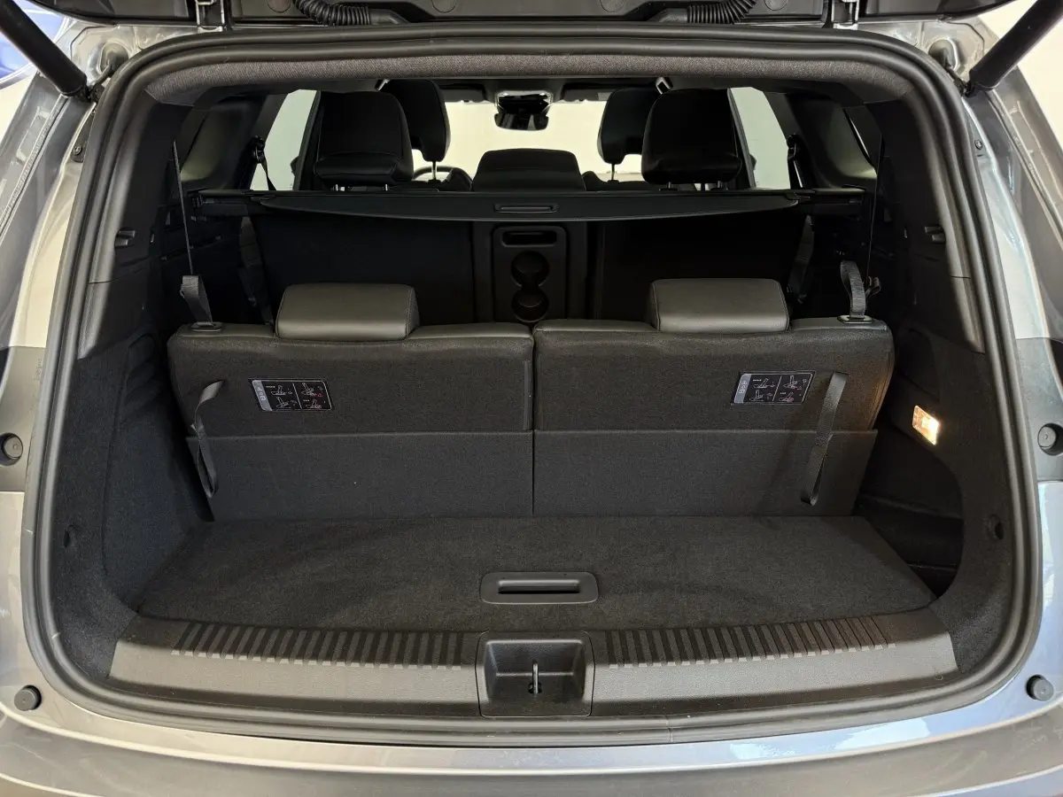 Coffre ouvert vu de l'arrière d'un Renault Espace gris foncé avec 3ème rangée de sièges rabattables et plancher plat.