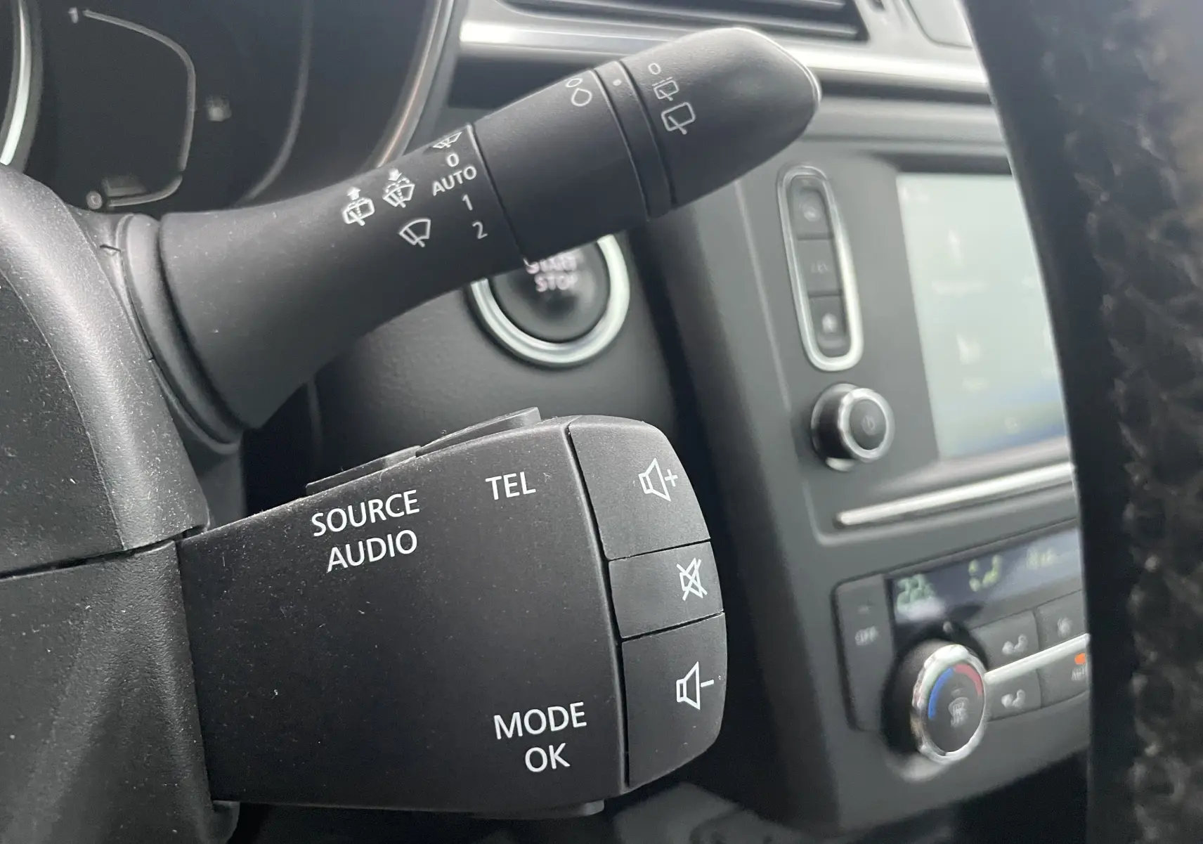 Gros plan sur la commande audio au volant du Renault Kadjar 1.5 DCI 110 EDC Bose, intérieur gris noir et console centrale visible.