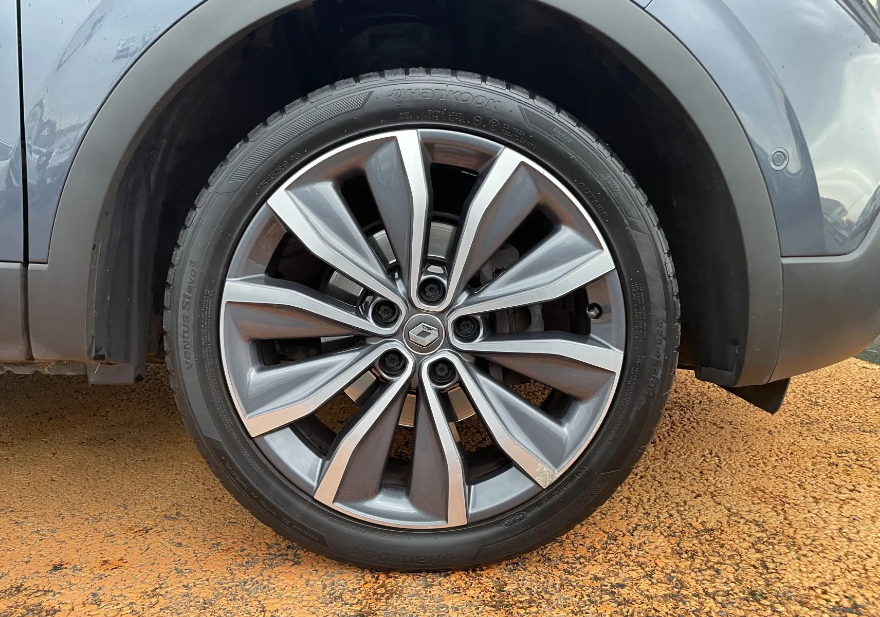 Gros plan sur la jante alliage biton 19 pouces du Renault Kadjar gris titanium, mettant en valeur le logo central Renault.