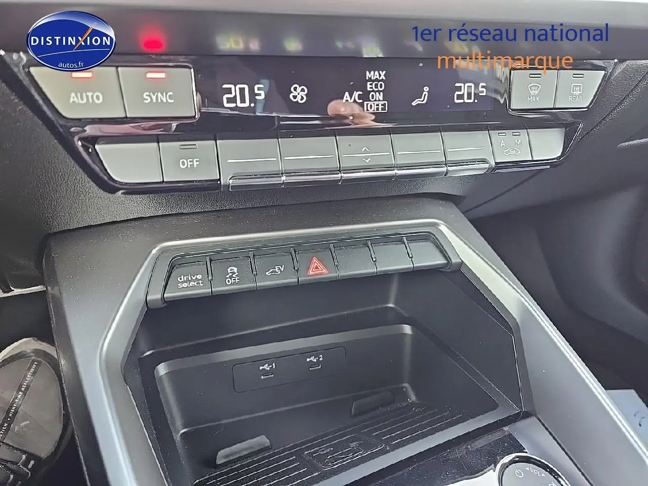 Vue rapprochée du tableau de bord et console centrale de l’Audi A3 Sportback 45 TFSI e gris Daytona, avec commandes climatisation et boutons fonctionnels.
