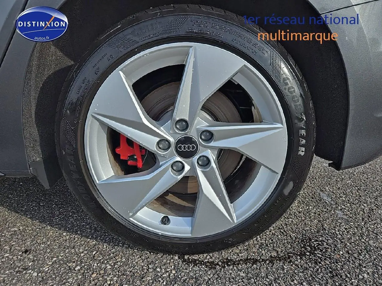 Gros plan sur la jante avant droite argentée d'une Audi A3 Sportback gris Daytona avec étrier de frein rouge visible.