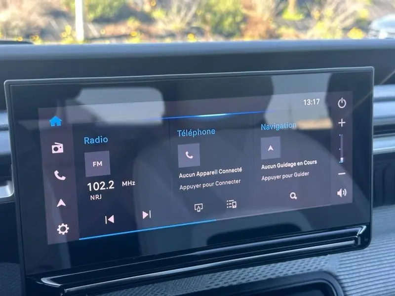 Écran tactile central de la Citroën C3 2025 affichant radio, téléphone et navigation, vue intérieure frontale.