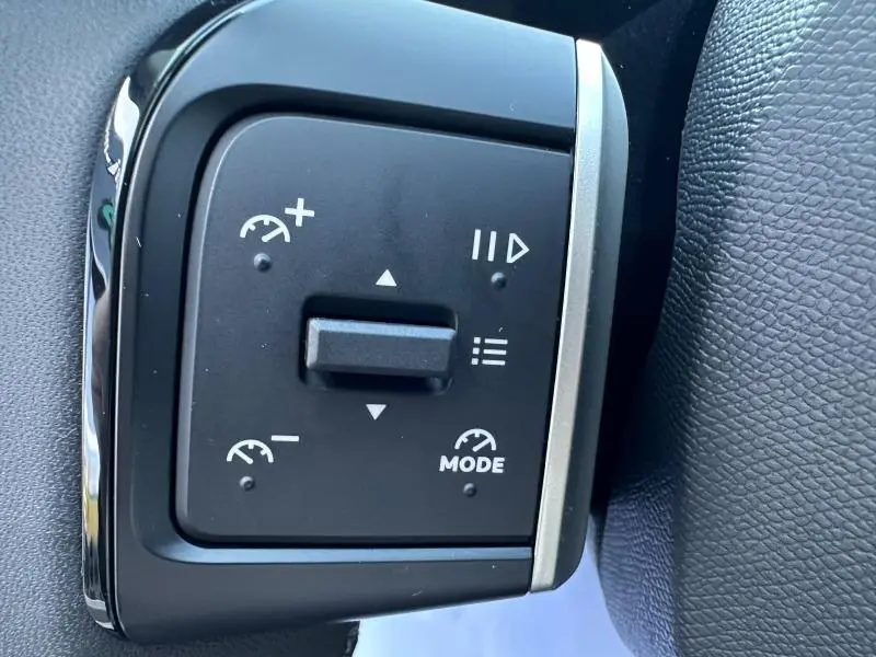 Gros plan sur les commandes noires du régulateur de vitesse au volant d'une Citroën C3 2025 Noir Perla Nera.