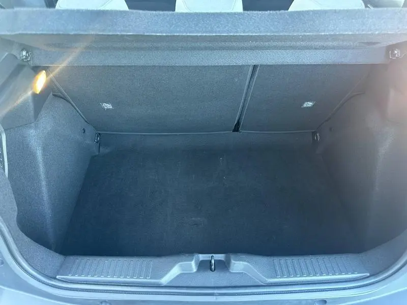 Vue intérieure du coffre noir de la Citroën C3 1.2 Turbo 100ch PLUS 2025, espace vide et éclairage latéral allumé.