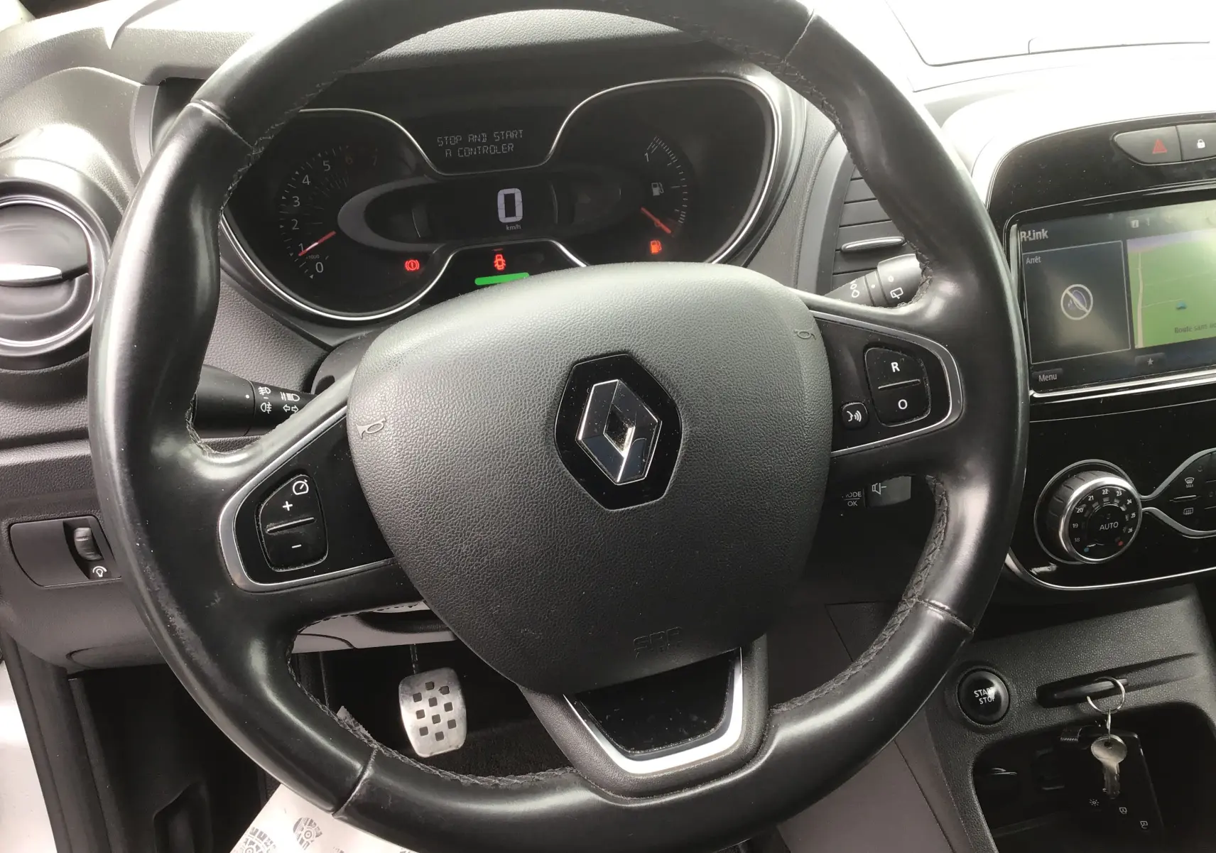 Vue intérieure centrée sur le volant et la console centrale du Renault Captur TCe 120 avec écran tactile et commandes au volant.