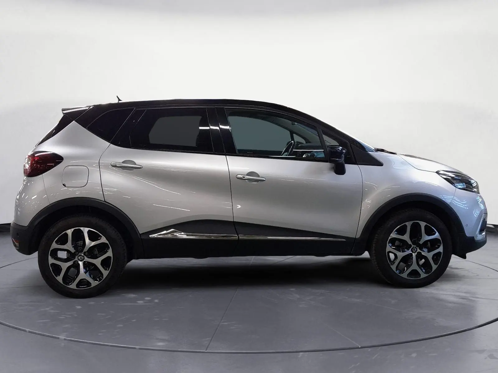 Renault Captur TCE 120 Energy Iridium 2017 en gris clair métal et toit noir, vue profil côté gauche avec jantes alliage.