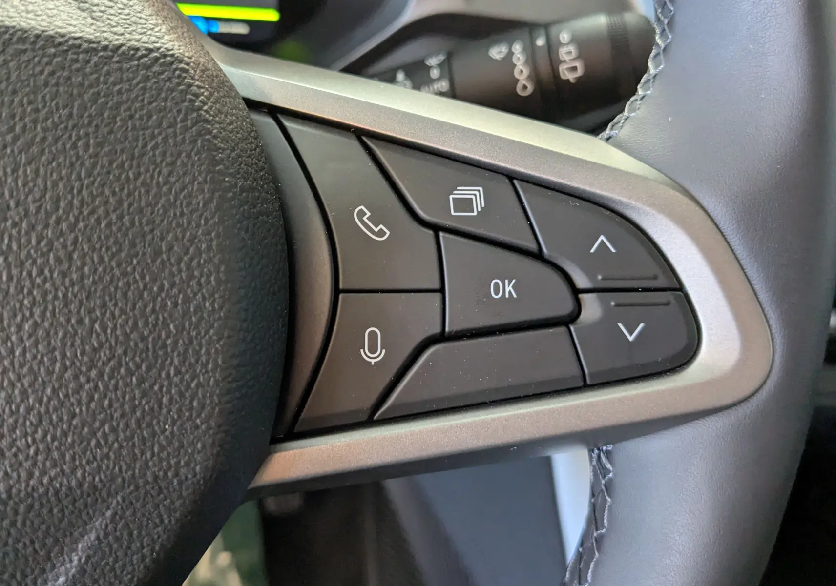 Gros plan sur les commandes multifonctions à droite du volant du Dacia Bigster Hybrid 155 gris schiste, boutons noirs et argentés.