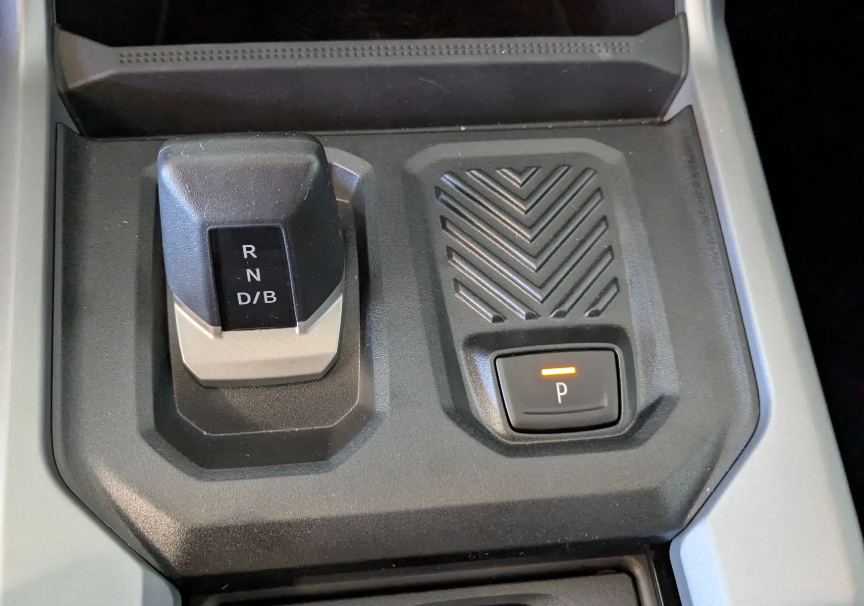 Gros plan sur la console centrale du Dacia Bigster Hybrid 155 Journey 2026 montrant le sélecteur de boîte auto et le bouton de parking.