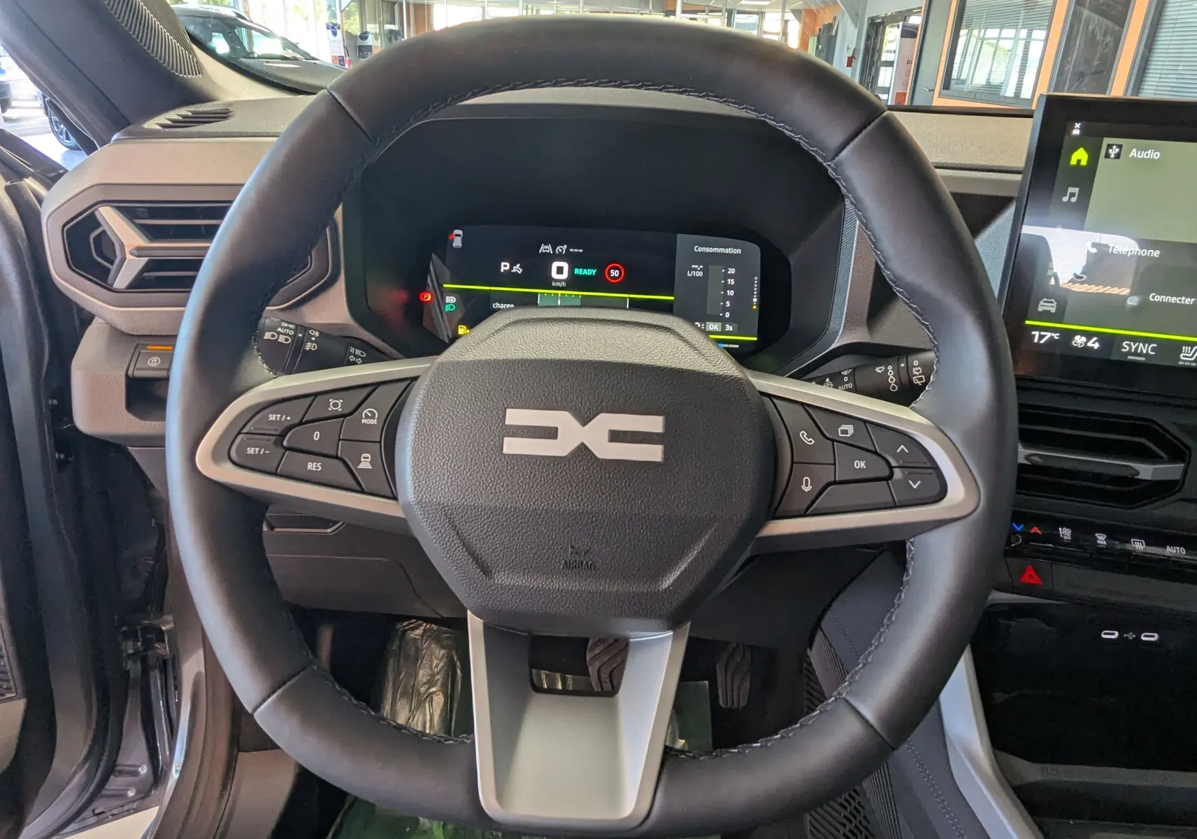 Vue centrée sur le volant du Dacia Bigster Hybrid 155 Journey avec tableau de bord numérique et écran tactile multimédia.