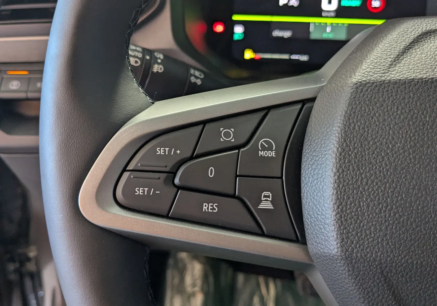 Gros plan sur les commandes au volant à gauche du Dacia Bigster Hybrid 155 Journey 2026, avec boutons de régulateur et mode.
