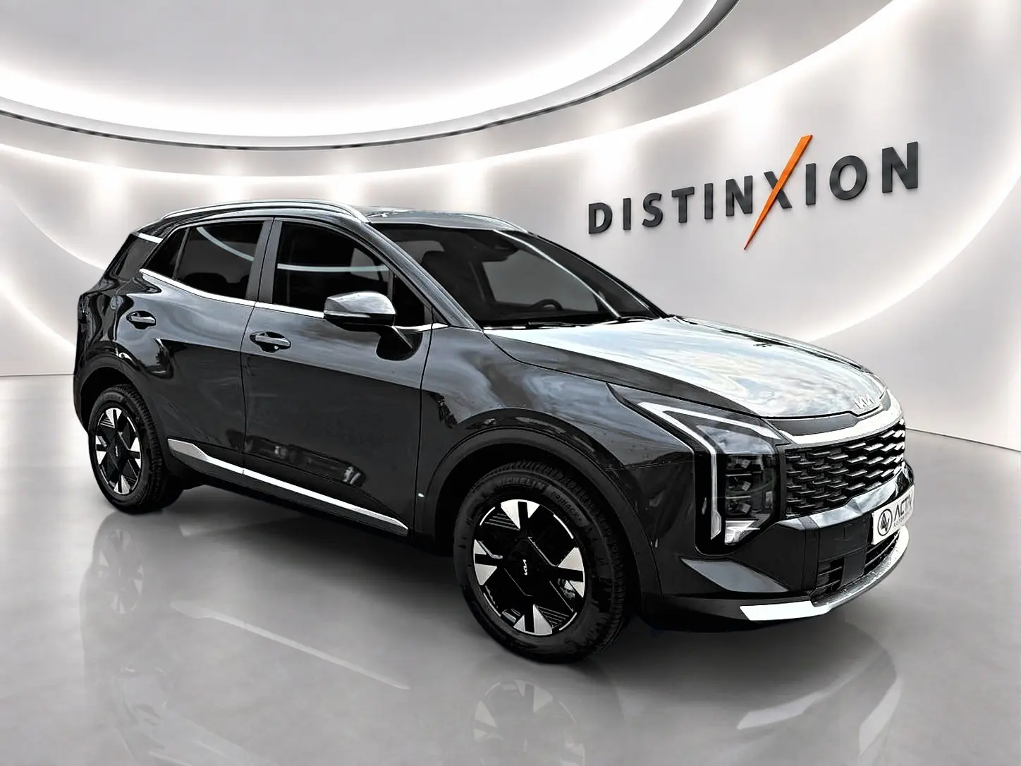 KIA Sportage 1.6 hybride gris eclipse en 3/4 avant droit, avec jantes alu noires et signature lumineuse LED verticale.
