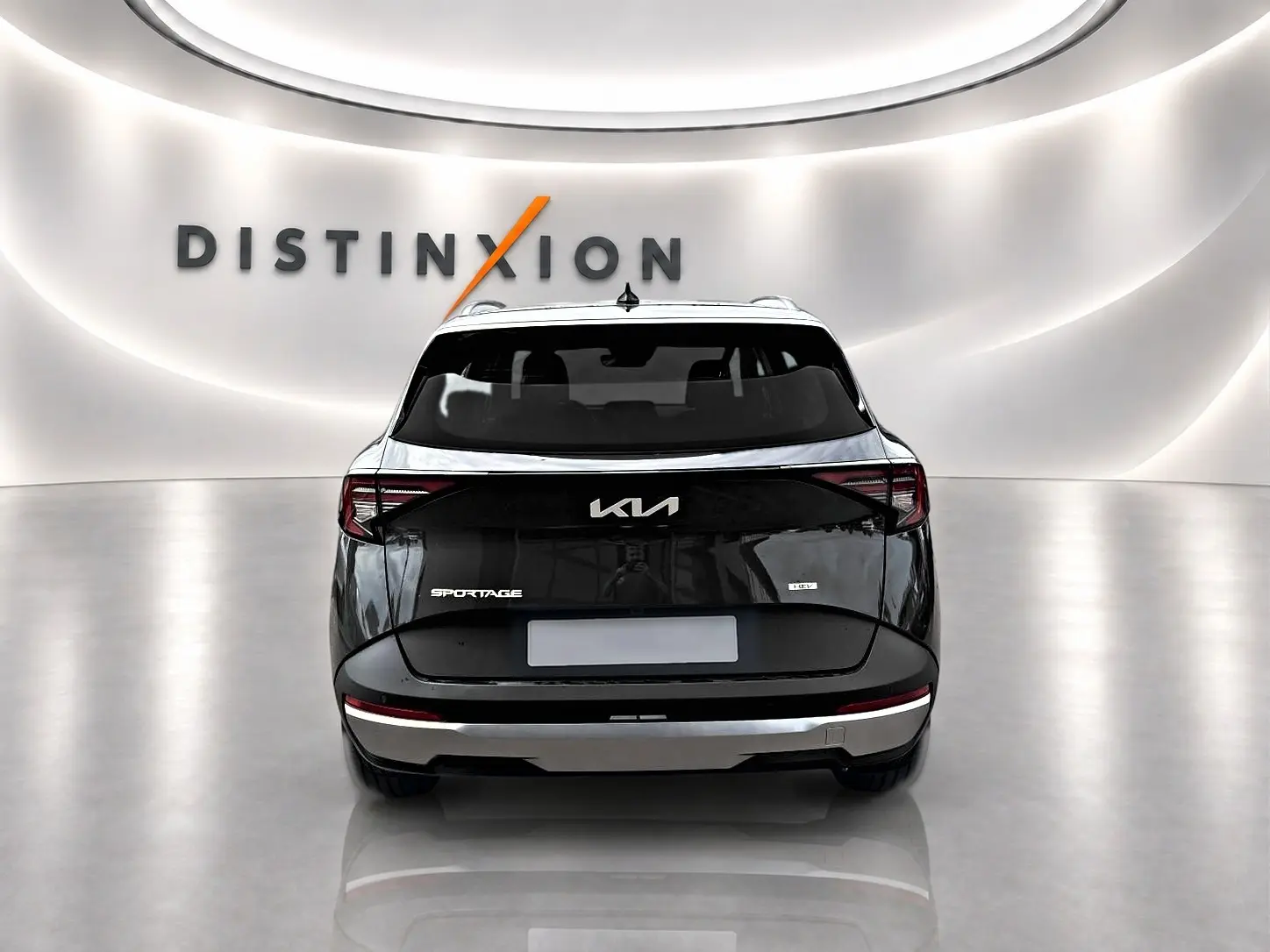 Vue arrière d’un KIA SPORTAGE gris eclipse 2026 avec feux arrière LED et logo distinctif dans un showroom lumineux.