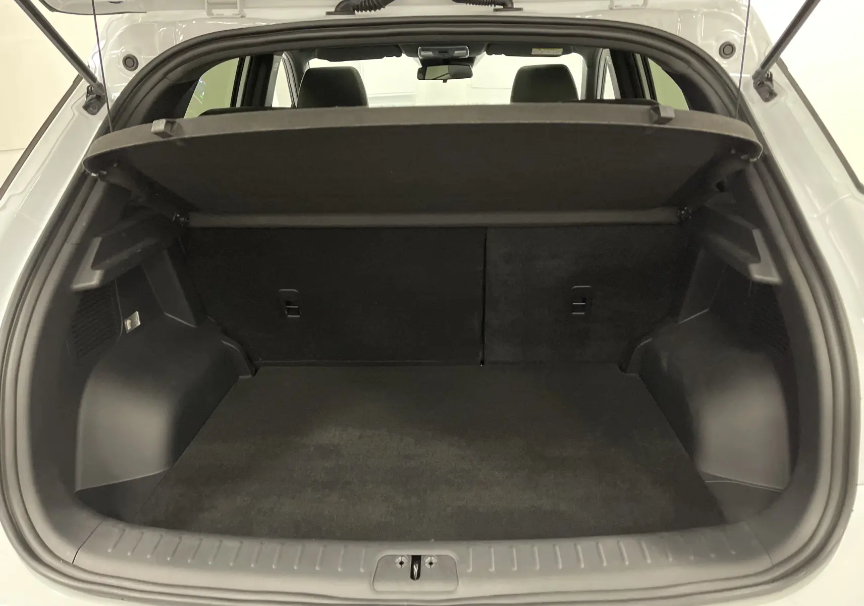 Coffre ouvert du SERES 3 Luxury blanc, vue arrière montrant un espace de chargement noir et banquette arrière.