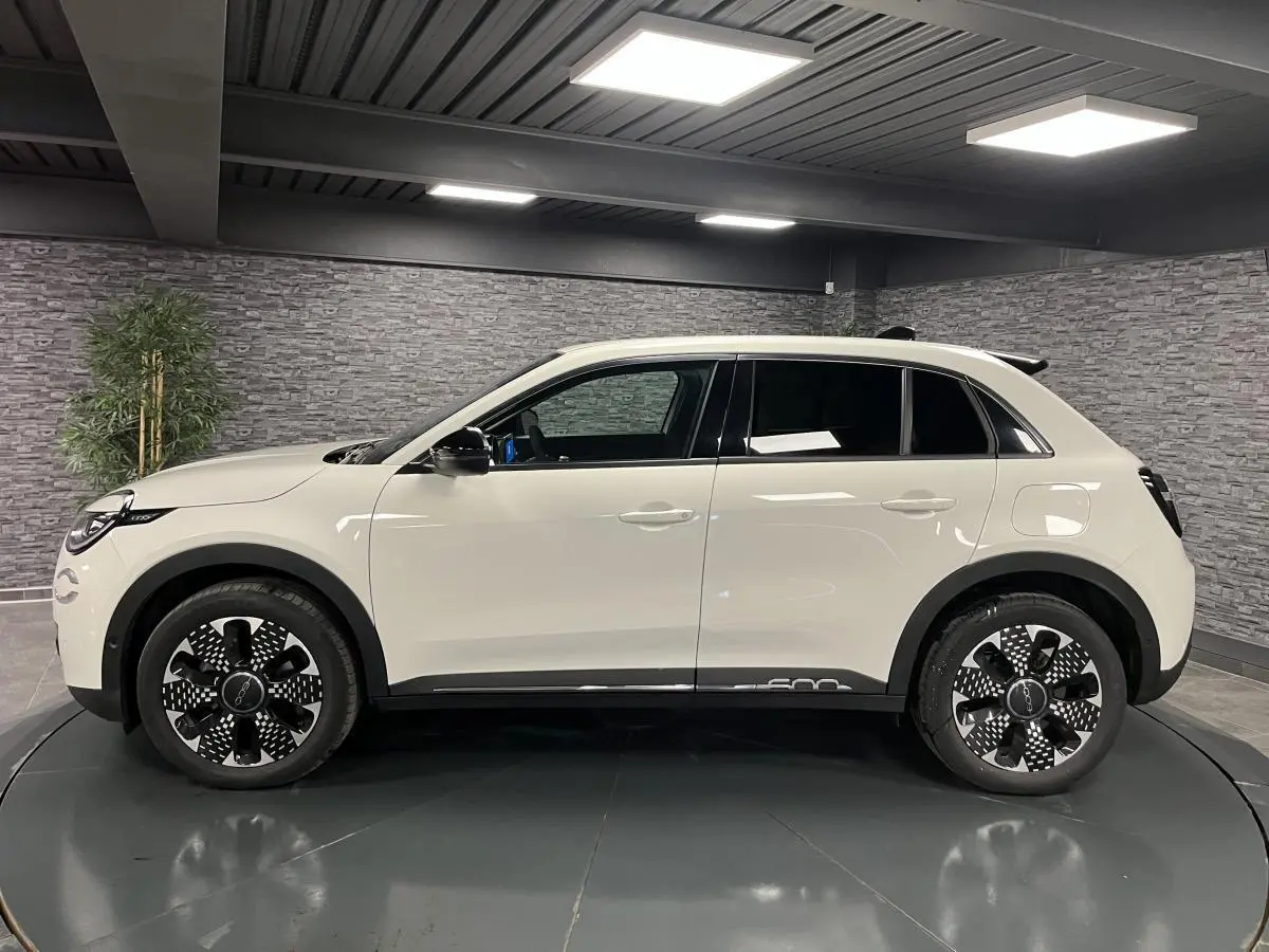 Profil côté gauche d'une FIAT 600 blanche 2024 avec jantes alliage diamantées et vitres arrière surteintées.