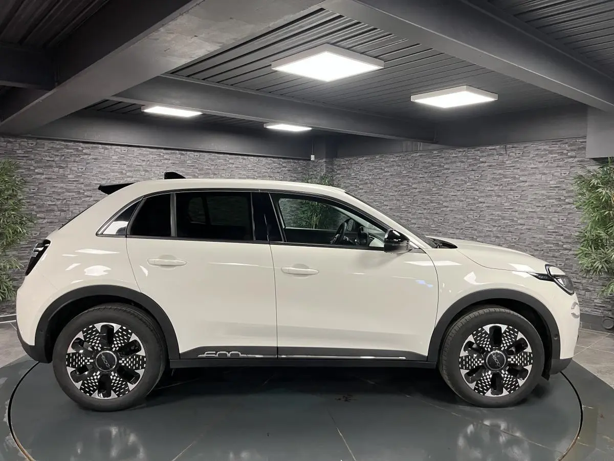 Vue de profil côté gauche d'un FIAT 600 blanc 2024 avec jantes alliage noires et logo 600 sur la bas de caisse.