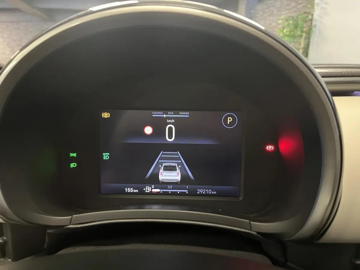 Combiné numérique 7 pouces affichant la vitesse et l'aide à la conduite du Fiat 600 blanc 2024 en vue frontale.