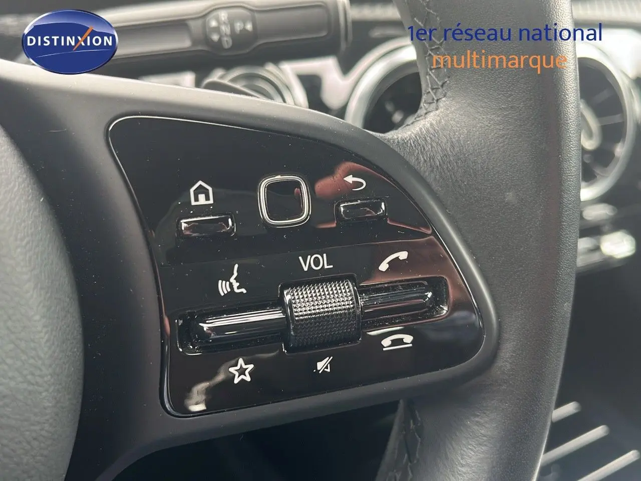 Gros plan sur les commandes de volume et téléphone au volant cuir noir d'une Mercedes CLA Shooting Brake argent iridium.