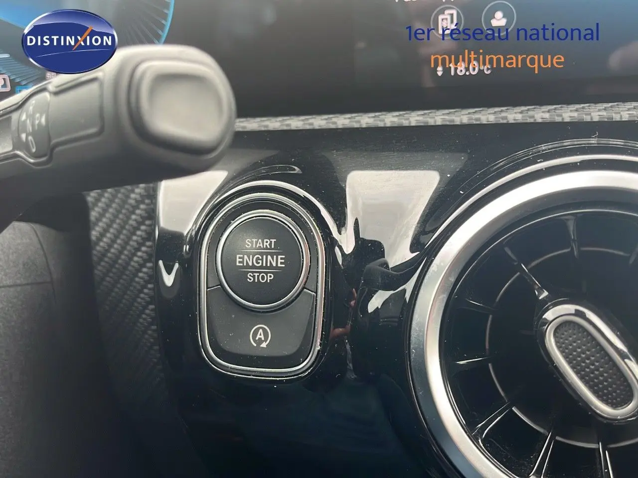 Bouton start/stop moteur et aérateur rond sur tableau de bord noir brillant d'une Mercedes Classe CLA Shooting Brake argent iridium.