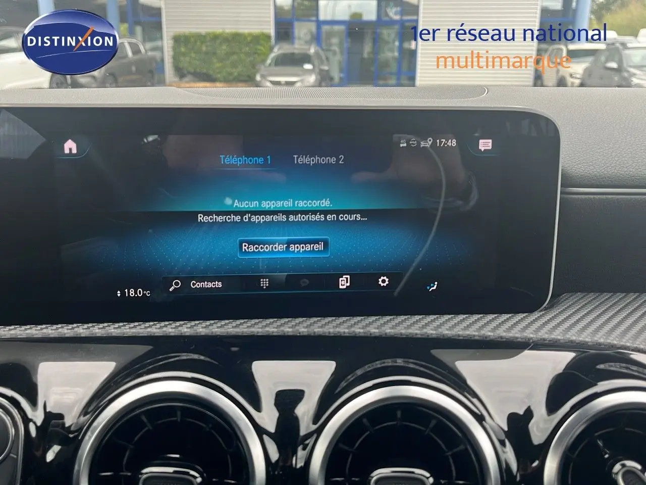 Tableau de bord intérieur d'une Mercedes Classe CLA Shooting Brake 180 argent, avec écran tactile et aérateurs ronds noirs.