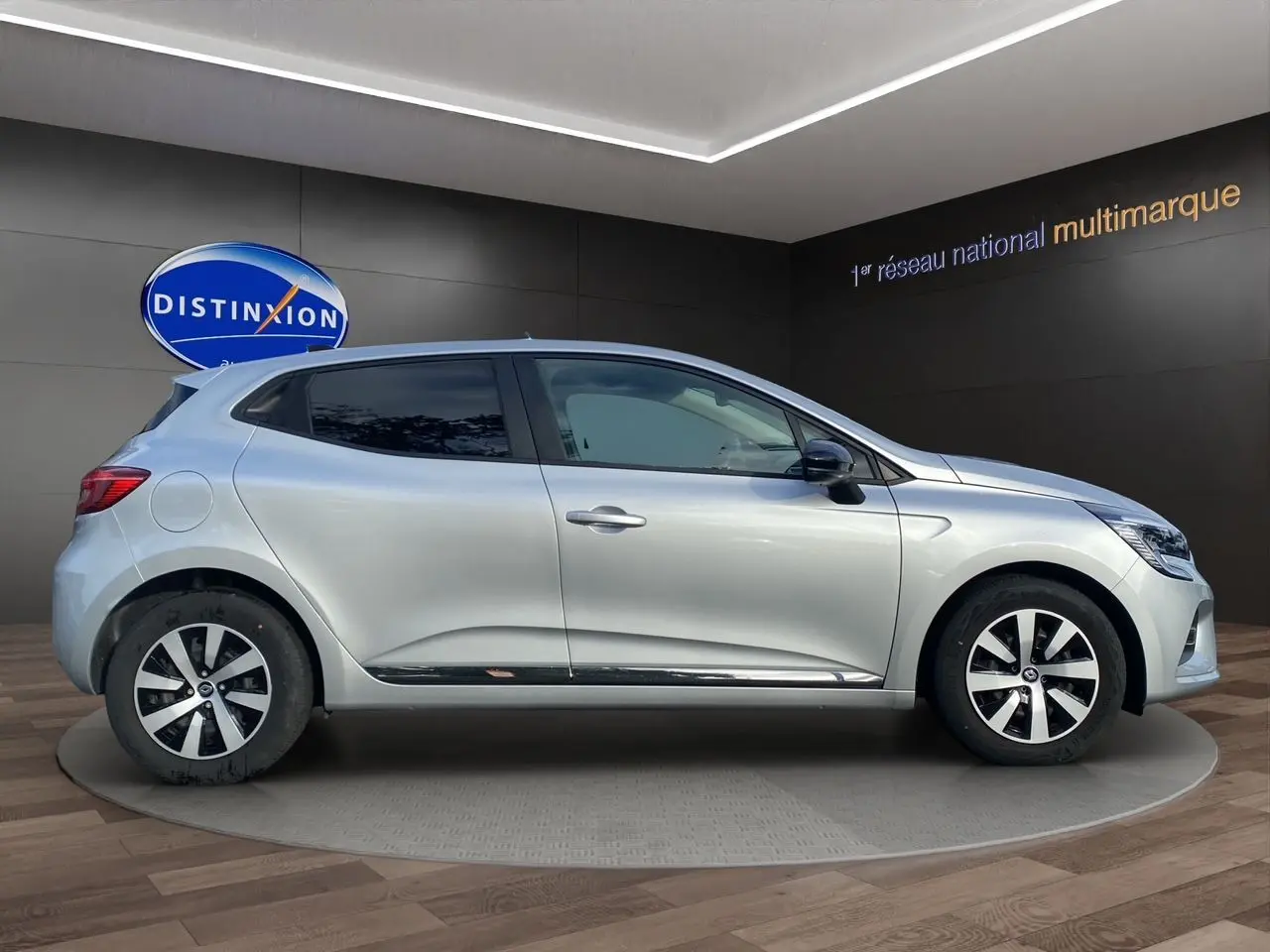 Profil côté gauche de la Renault Clio V gris Highland 2023, vitres arrière surteintées et jantes distinctives.