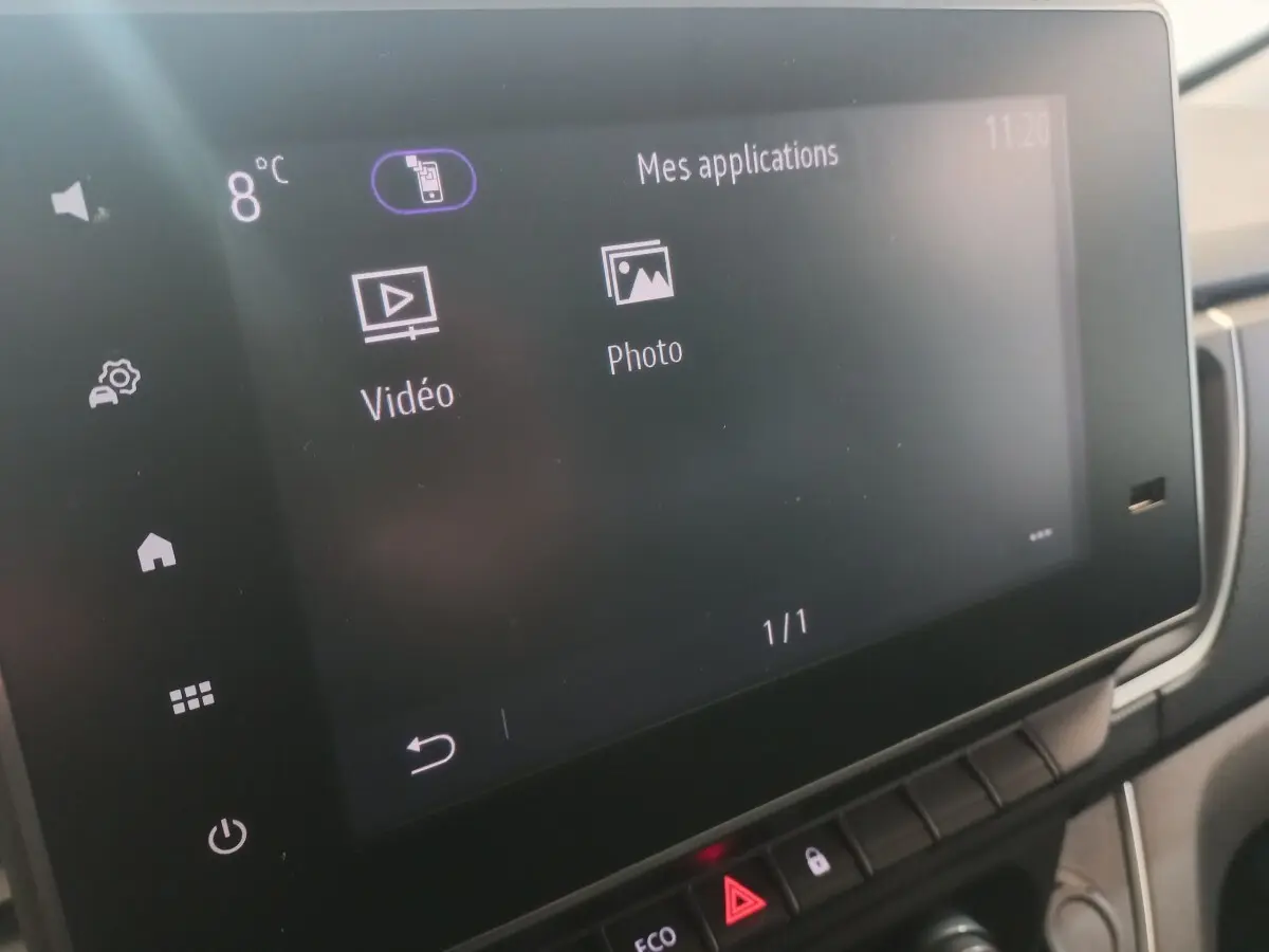Écran tactile central du tableau de bord du Renault Trafic Fourgon blanc, affichant les applications vidéo et photo.