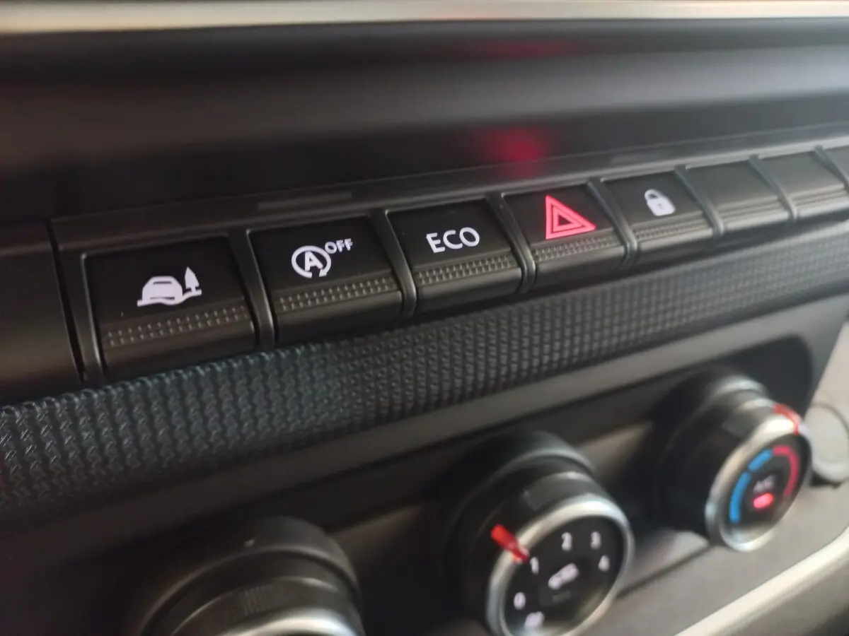Gros plan sur les boutons de commande du tableau de bord du Renault Trafic Fourgon blanc, avec mode ECO et alerte.