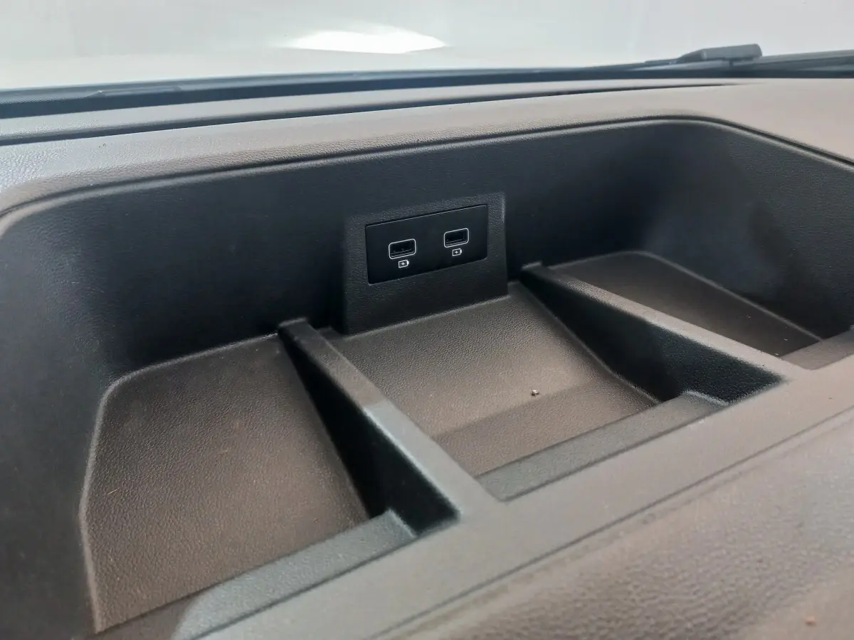 Gros plan sur le rangement noir du tableau de bord avec deux ports USB du Renault Trafic Fourgon blanc 2022.