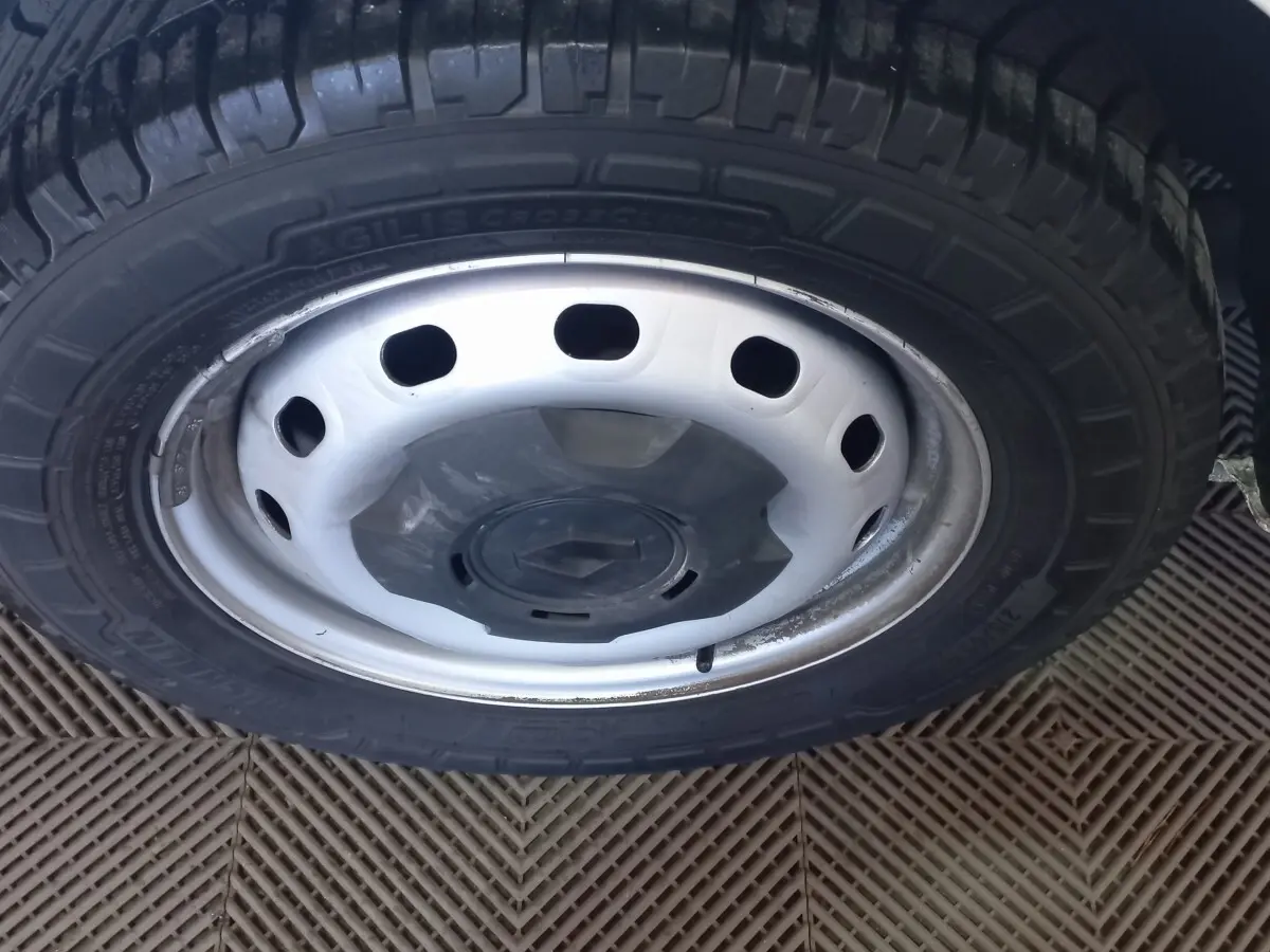 Gros plan sur la roue avant droite du Renault Trafic Fourgon blanc, avec jante acier et logo Renault central.