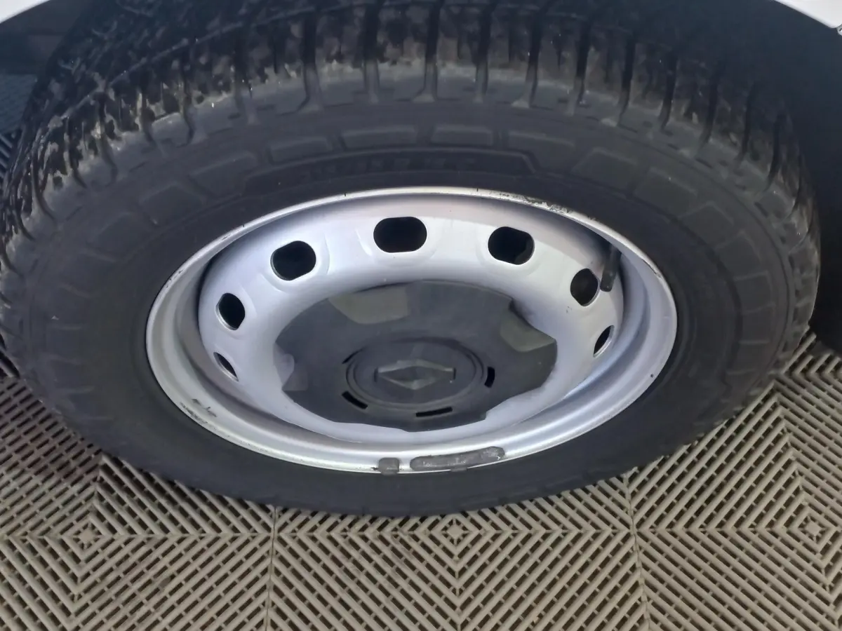 Gros plan sur la roue avant droite blanche du Renault Trafic Fourgon avec jante acier et logo central noir.