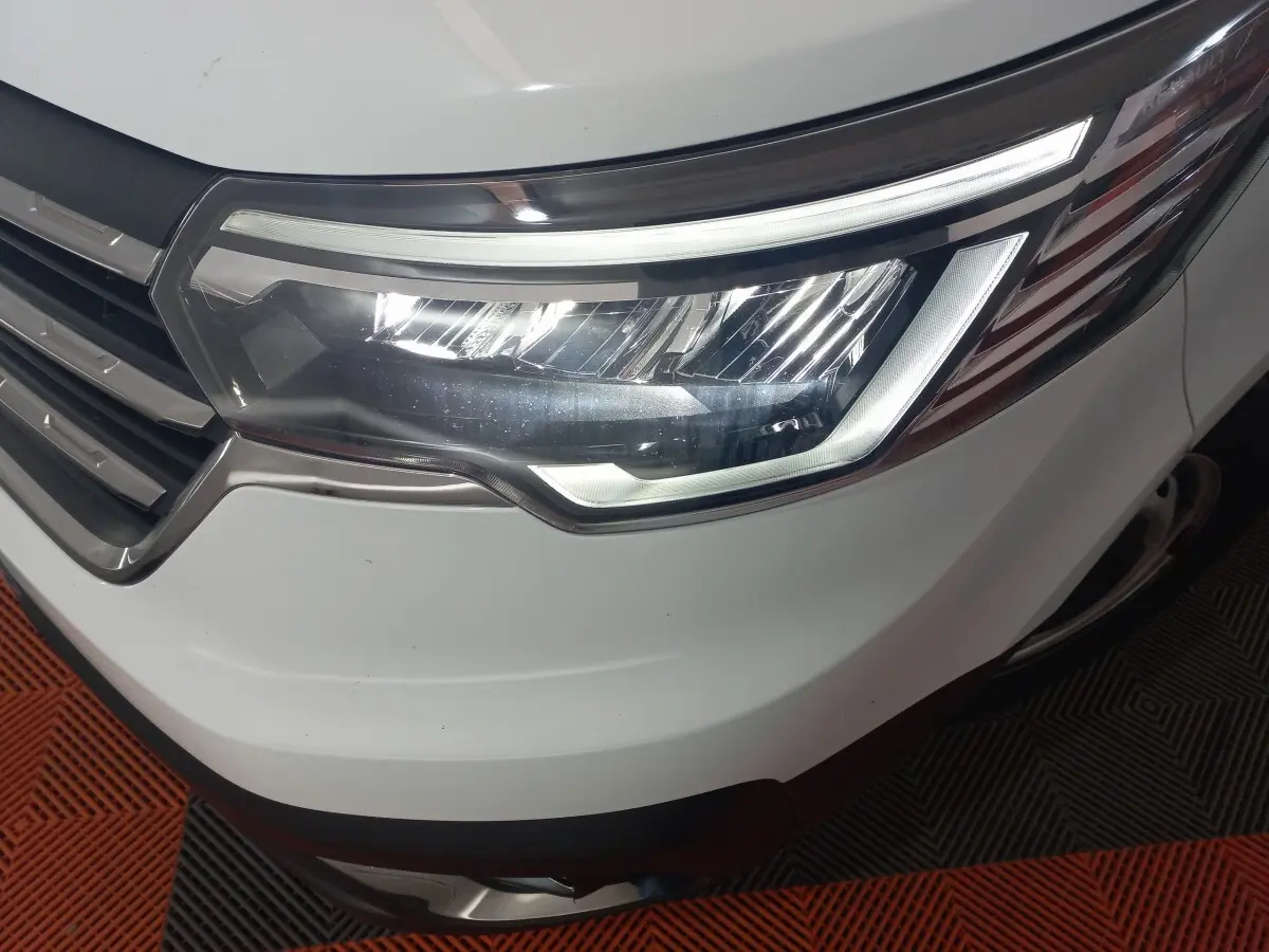 Gros plan sur le phare avant droit blanc du Renault Trafic Fourgon 2022 avec calandre chromée et éclairage LED.