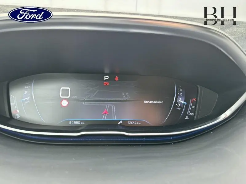 Affichage numérique du tableau de bord d'une Peugeot 5008 gris Artense, avec navigation et compteurs digitaux.