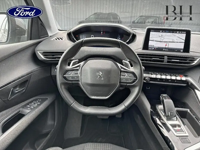 Vue intérieure centrée sur le volant cuir multifonction et l’écran tactile du tableau de bord du Peugeot 5008 gris Artense.