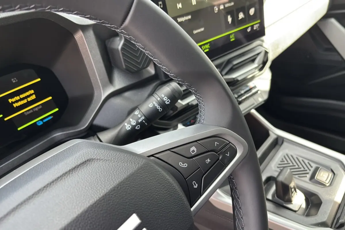 Gros plan sur le volant cuir et la console centrale du Dacia Bigster Hybrid 155 Journey Plus, intérieur moderne noir et gris.