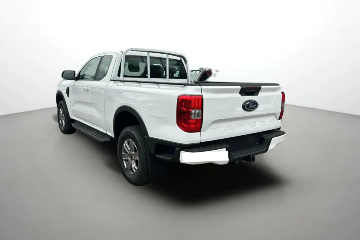Ford Ranger blanc glacier en 3/4 arrière droit avec benne ouverte et marchepieds latéraux visibles.