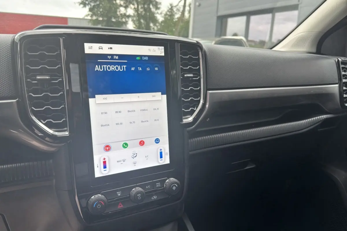 Vue rapprochée de la console centrale noire du Ford Ranger 2025 avec écran tactile vertical et commandes climatisation.