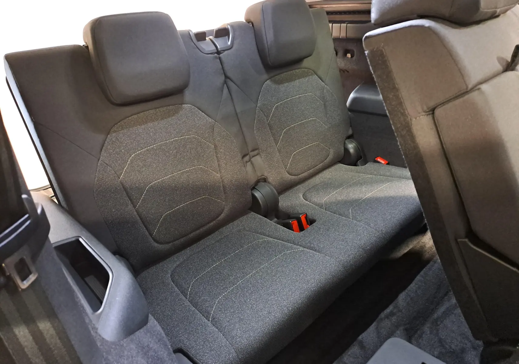 Vue rapprochée des sièges arrière en tissu gris du Skoda Kodiaq 2025, version 7 places, avec appuie-têtes intégrés.