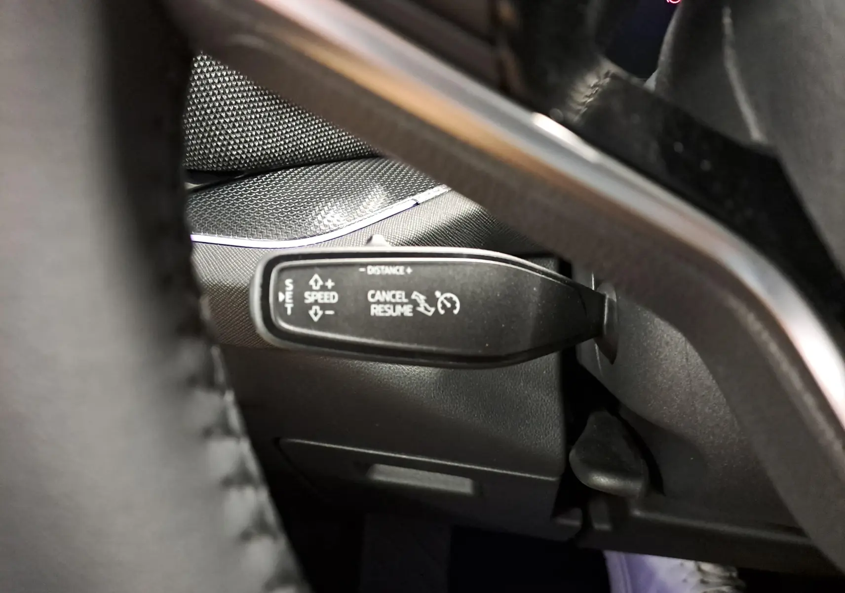 Gros plan sur la commande de régulateur de vitesse à gauche du volant du Skoda Kodiaq gris graphite 2025.