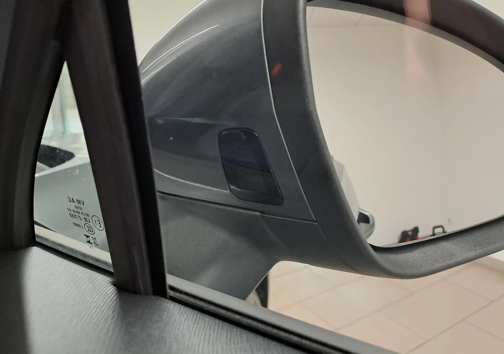 Gros plan sur le rétroviseur extérieur côté gauche du Skoda Kodiaq gris graphite, avec vitrage acoustique visible.