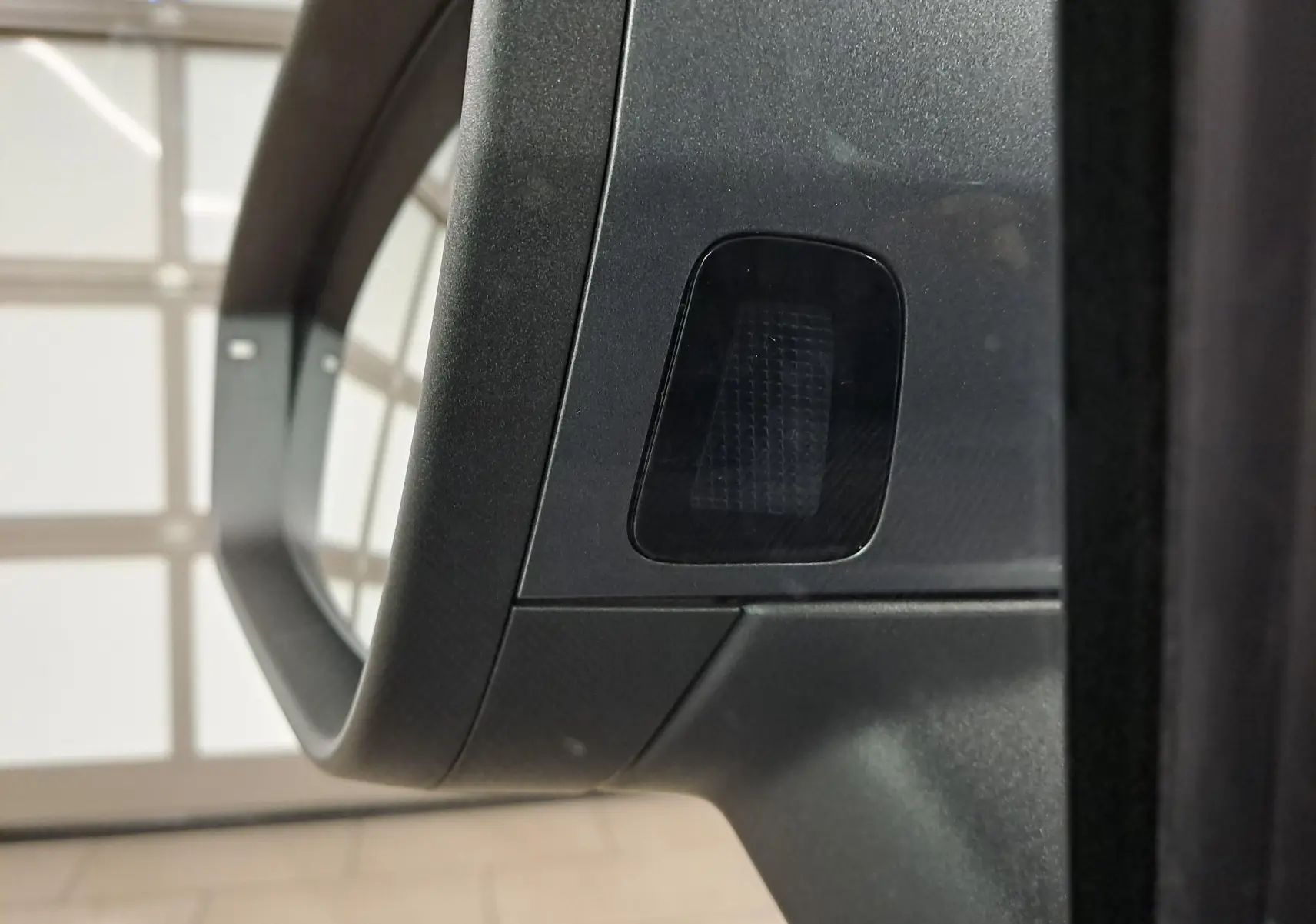 Gros plan sur le rétroviseur extérieur gris graphite du Skoda Kodiaq 2025 avec capteur intégré visible.