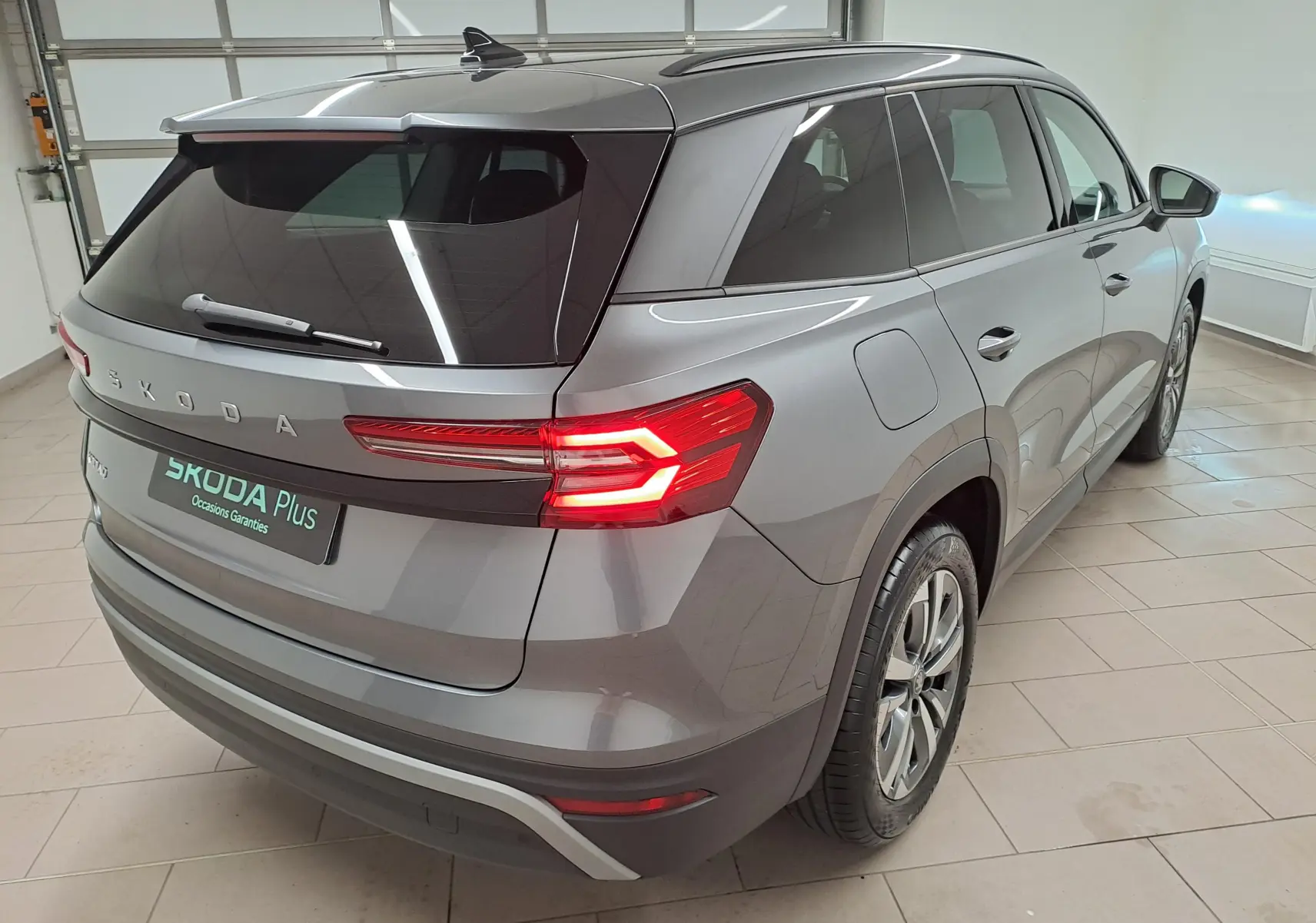 Vue 3/4 arrière droite du Skoda Kodiaq gris graphite 2025 avec vitres surteintées et jantes alliage anthracite.
