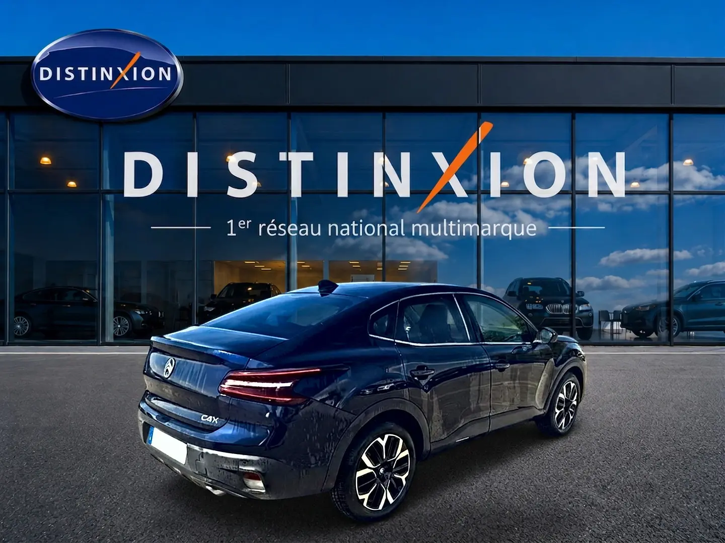 Vue 3/4 arrière droite d'une Citroën C4 X bleu nuit, avec feux arrière LED et jantes alliage distinctives.