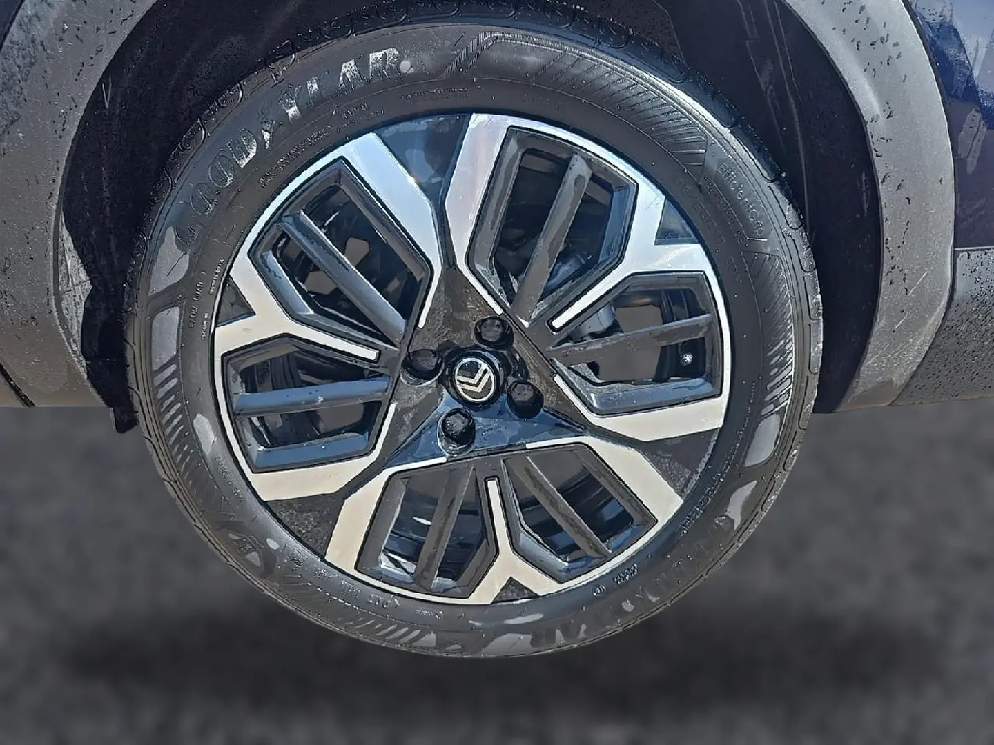 Gros plan sur la jante alu bicolore noire et argentée d’une Citroën C4 X bleu, avec pneu Goodyear visible.