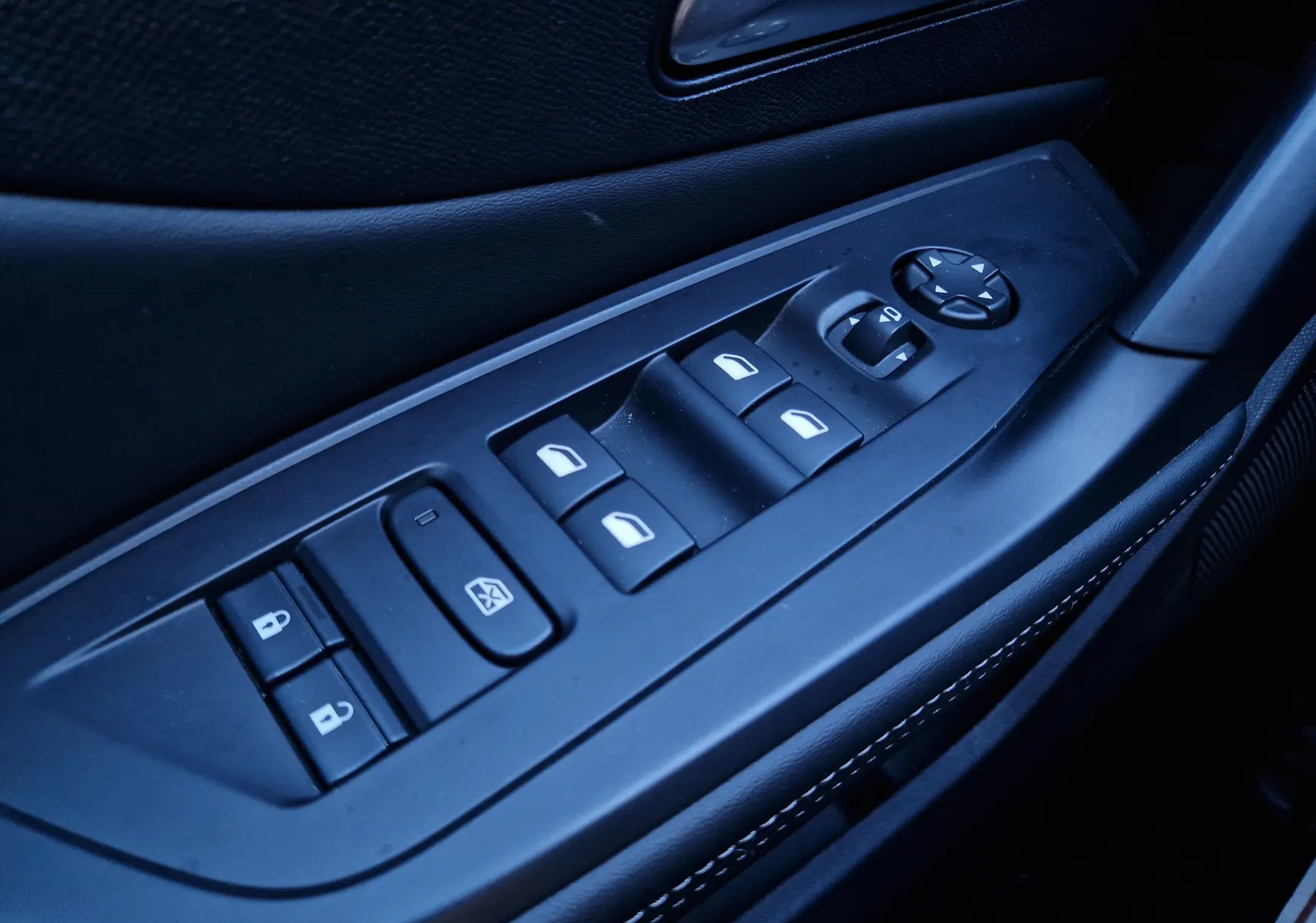 Gros plan sur les commandes de lève-vitres et rétroviseurs côté gauche d'une Peugeot 308 1.2 Hybrid 145 gris Artense.