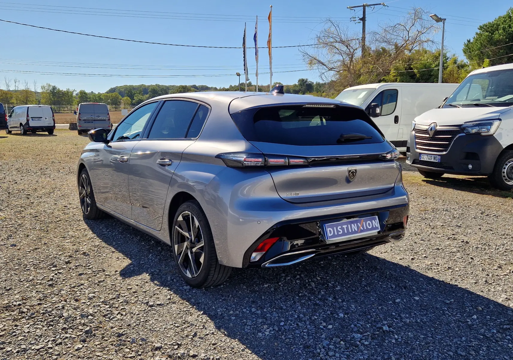 Peugeot 308 gris Artense vue 3/4 arrière droit, avec feux arrière fins et jantes alliage noires.