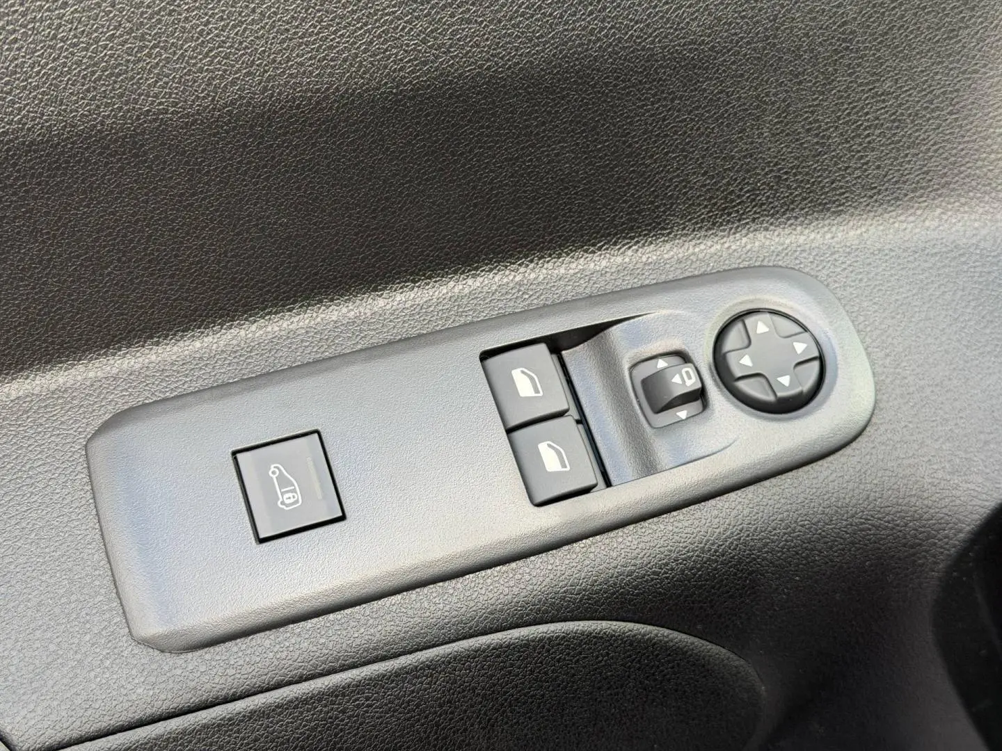 Gros plan sur les commandes de réglage des rétroviseurs et des vitres côté conducteur du Peugeot Partner blanc Icy 2026.