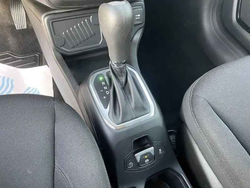 Vue rapprochée de la console centrale avec levier de boîte automatique et sièges en tissu noir d'une Jeep Renegade 2021.