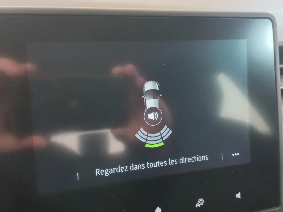 Écran tactile intérieur montrant l'alerte de capteurs de distance sur Renault Clio Business blanc, vue de dessus du véhicule.