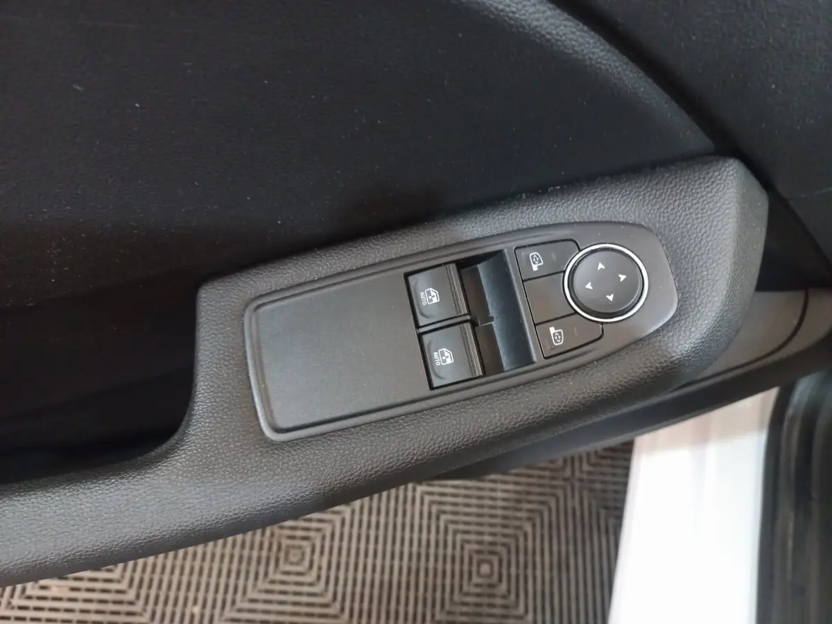 Gros plan sur les commandes des vitres et rétroviseurs côté conducteur de la Renault Clio Business blanche 2021.