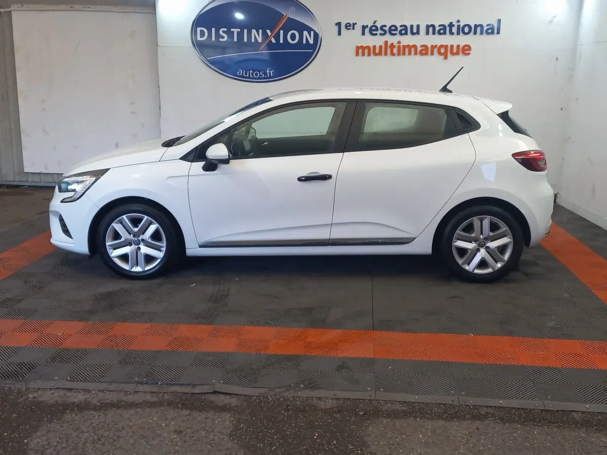 Profil droit d'une Renault Clio Business blanche 2021, avec jantes alliage et poignées de porte noires visibles.