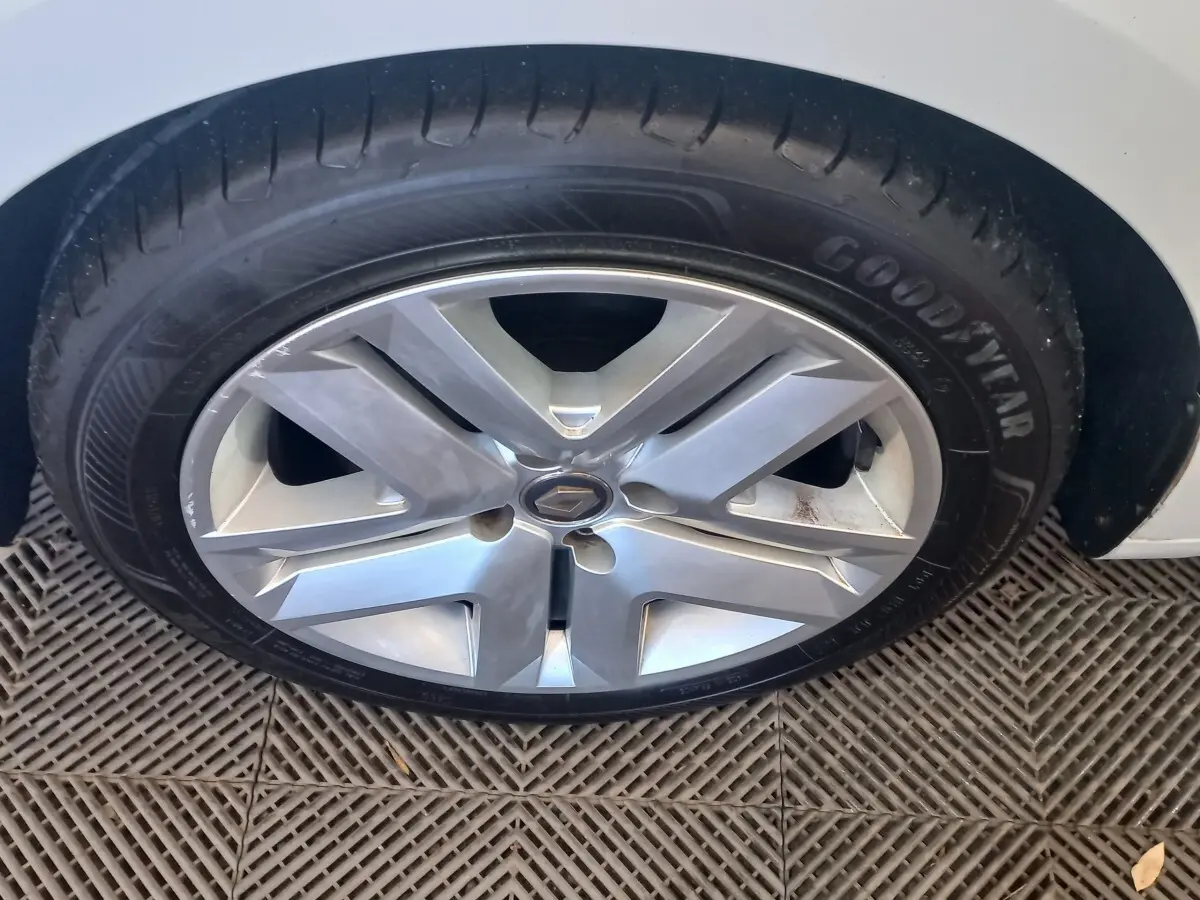 Gros plan sur la roue avant droite blanche d’une Renault Clio Business 2021 avec jante alliage et pneu Goodyear.